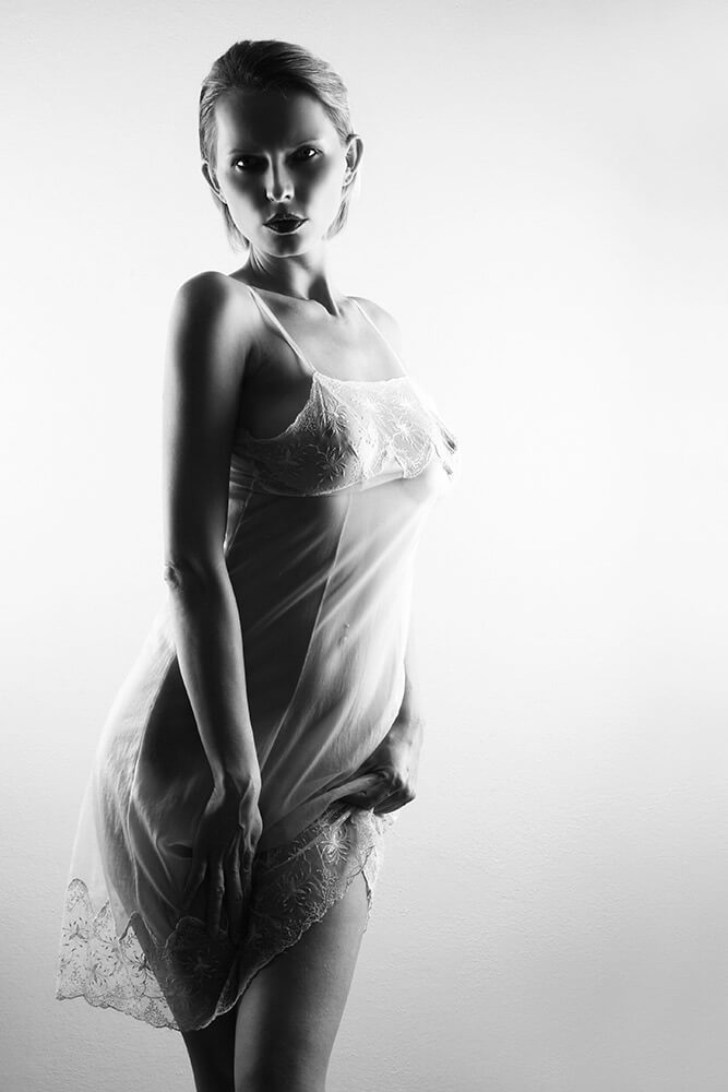 black and white boudoir photo of a woman in a negligee