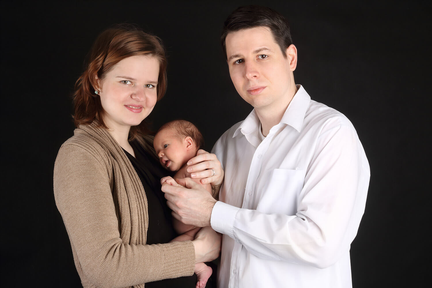 rodinná fotografie s novorozencem na tmavém pozadí
