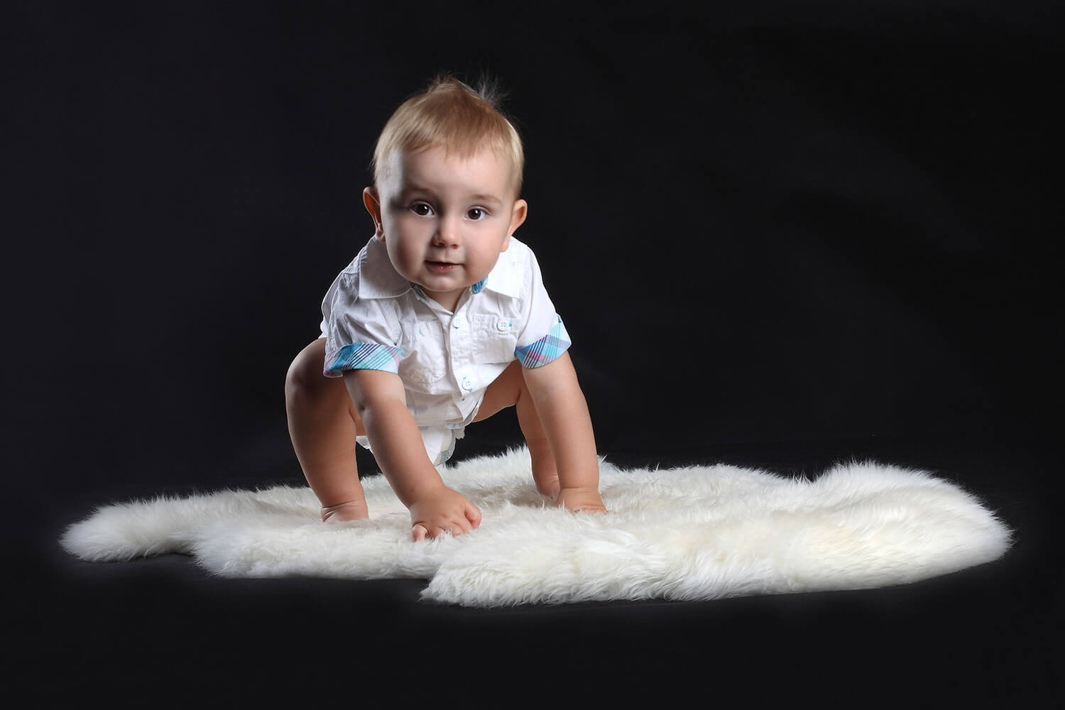family photo of a toddler on a fur on a dark background