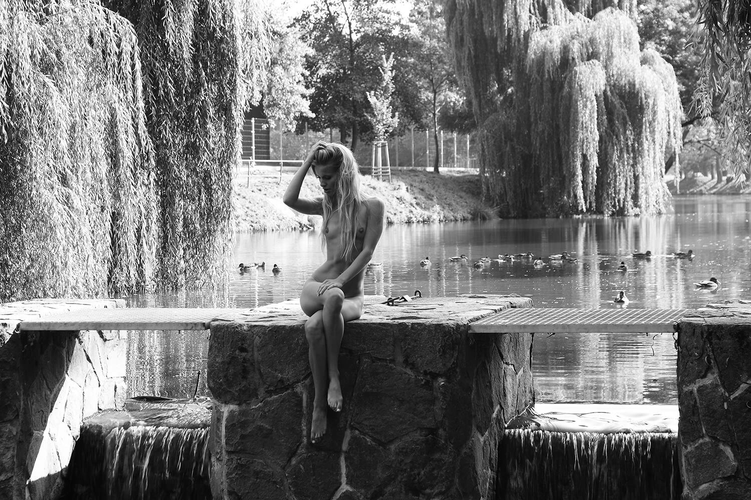 black and white fine art nude of a woman on the shore of a pond
