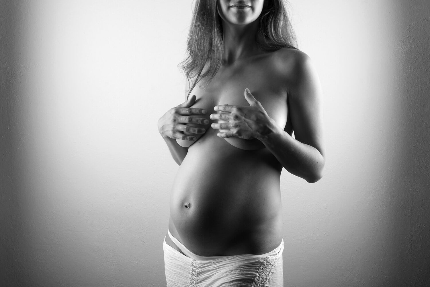 černobílá těhotenská fotografie s bílou sukní na světlém pozadí