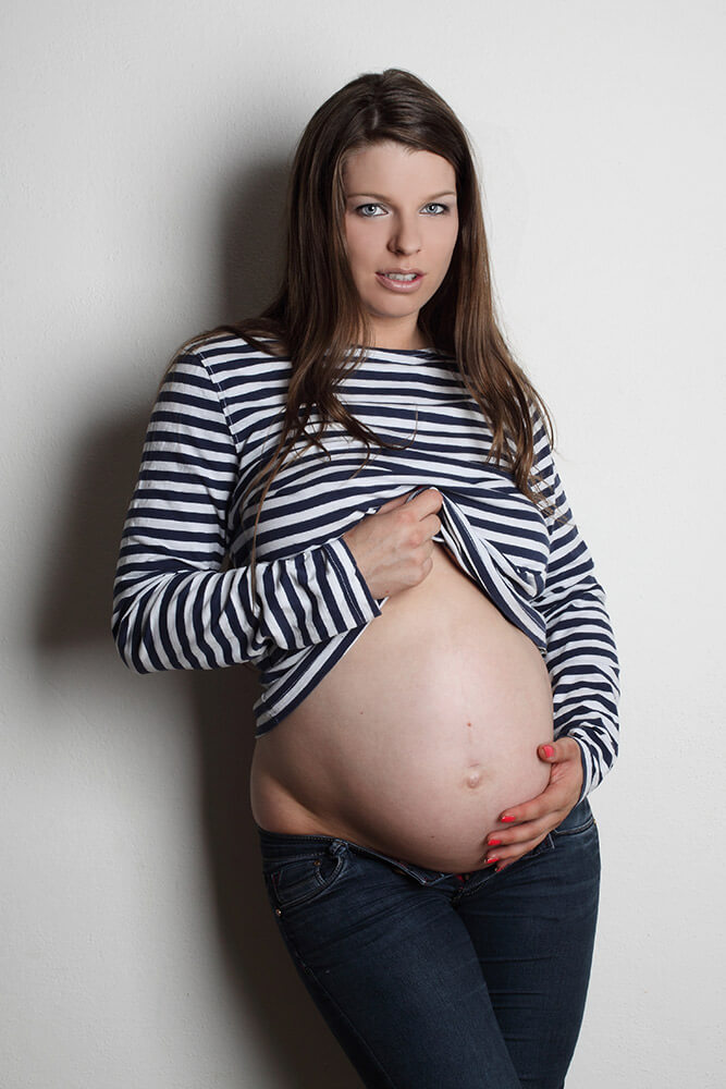 těhotenská fotografie s pruhovaným trikem na světlém pozadí