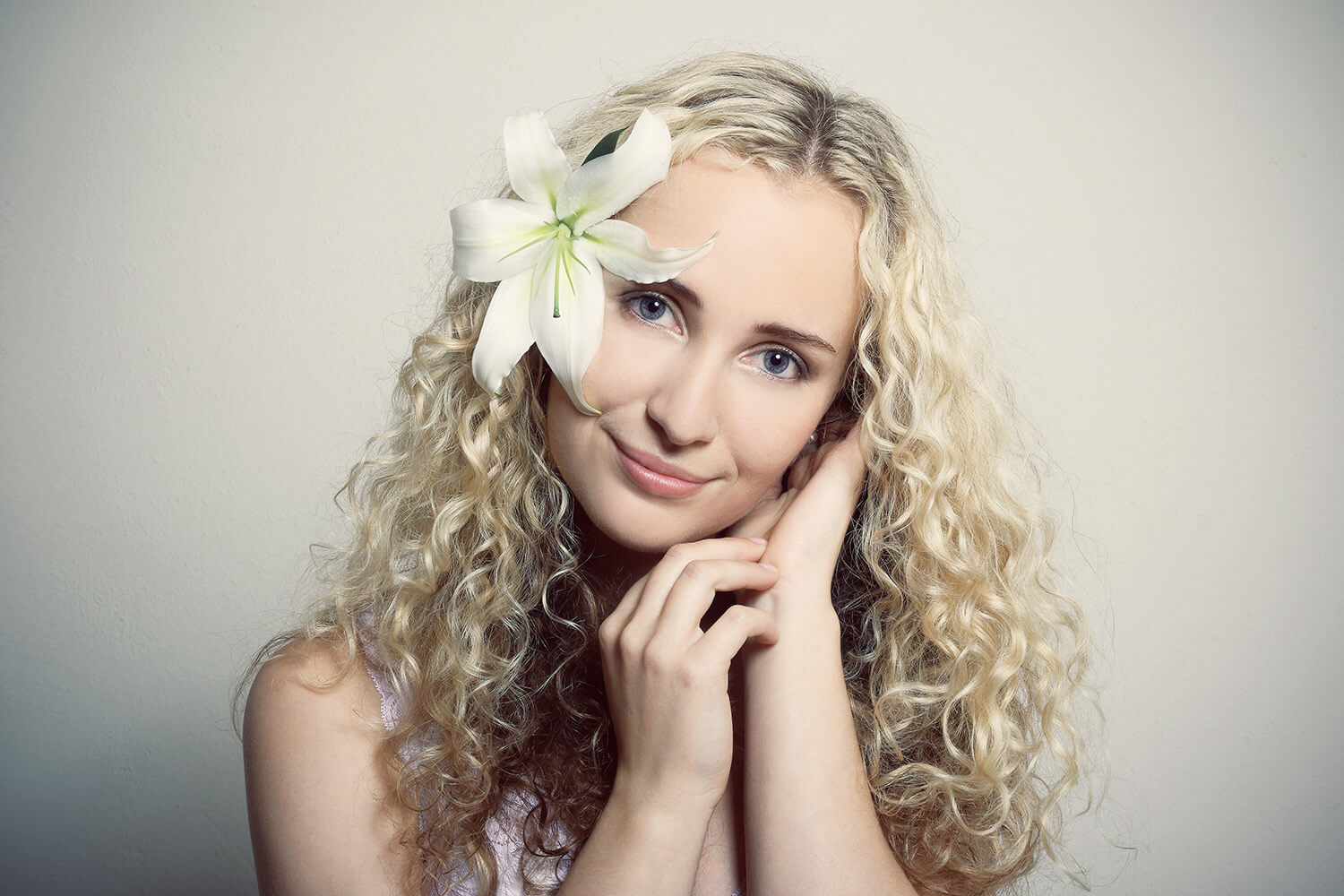 portrait of a woman with a lily on a light background