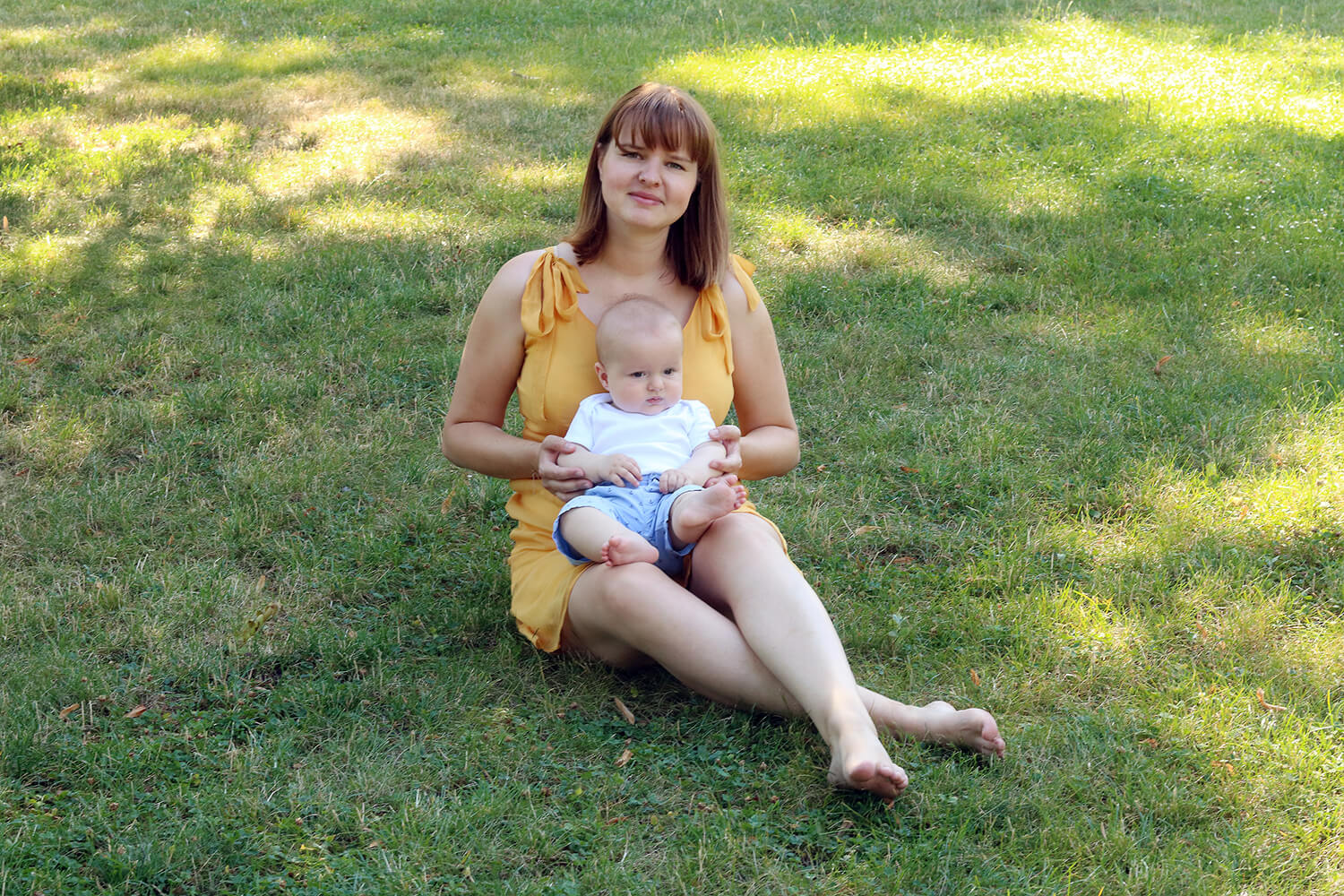 family photo of mom with toddler on the grass