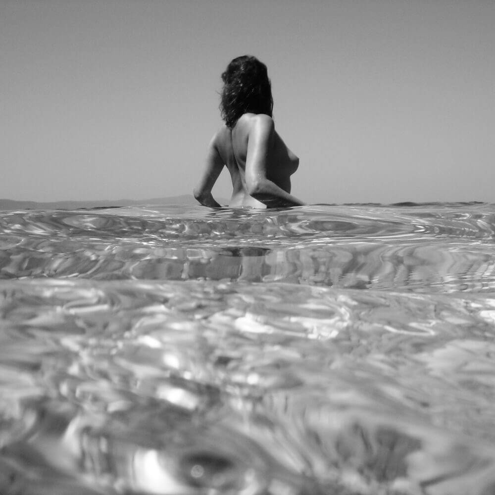 black and white fine art nude of a woman with sea surface