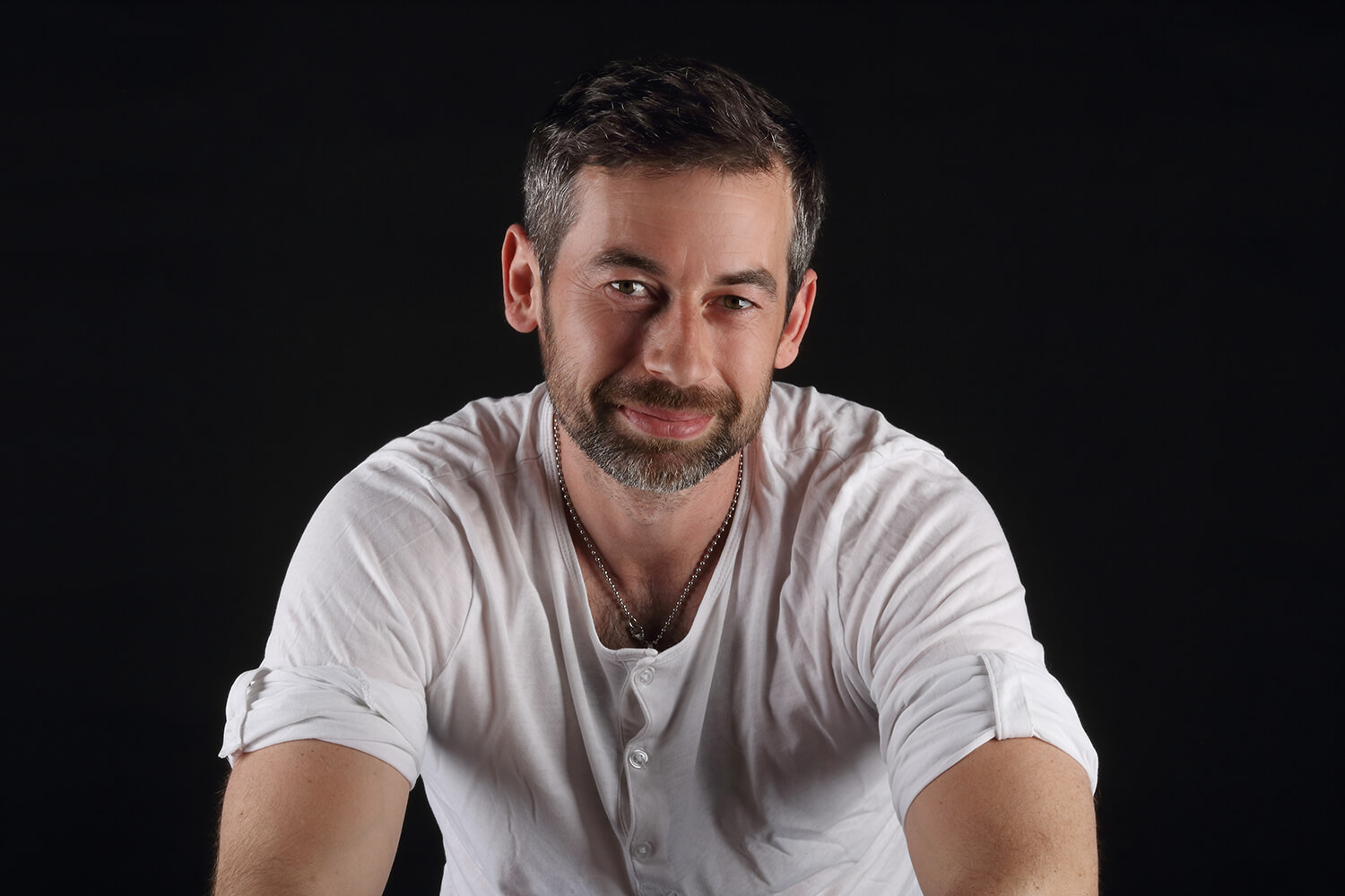 male portrait in a white T-shirt on a dark background
