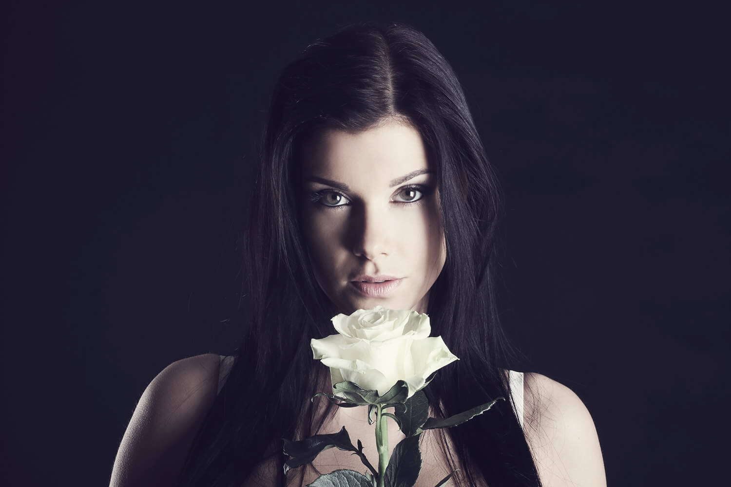 ženský portrét s růží na tmavém pozadí