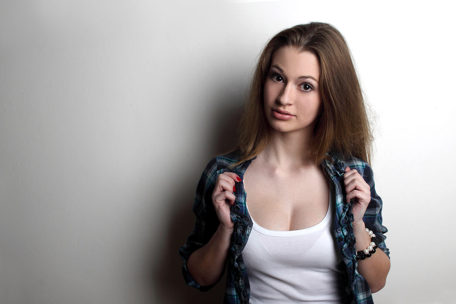 female portrait in a white tank top and a shirt on a light background