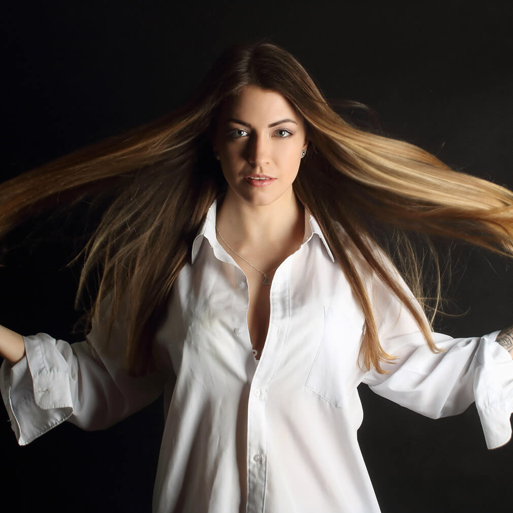 fotografie ženy v bílé košili s rozevlátými vlasy kolem hlavy