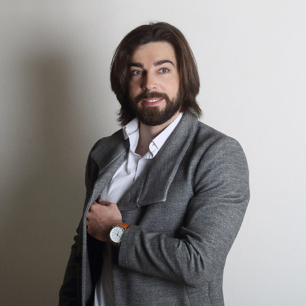 portrét muže v šedém saku na světlém pozadí